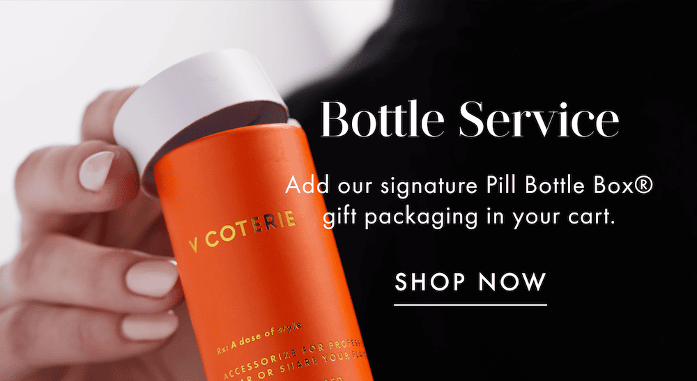 A model is holding our signature Pill Bottle Box gift packaging.