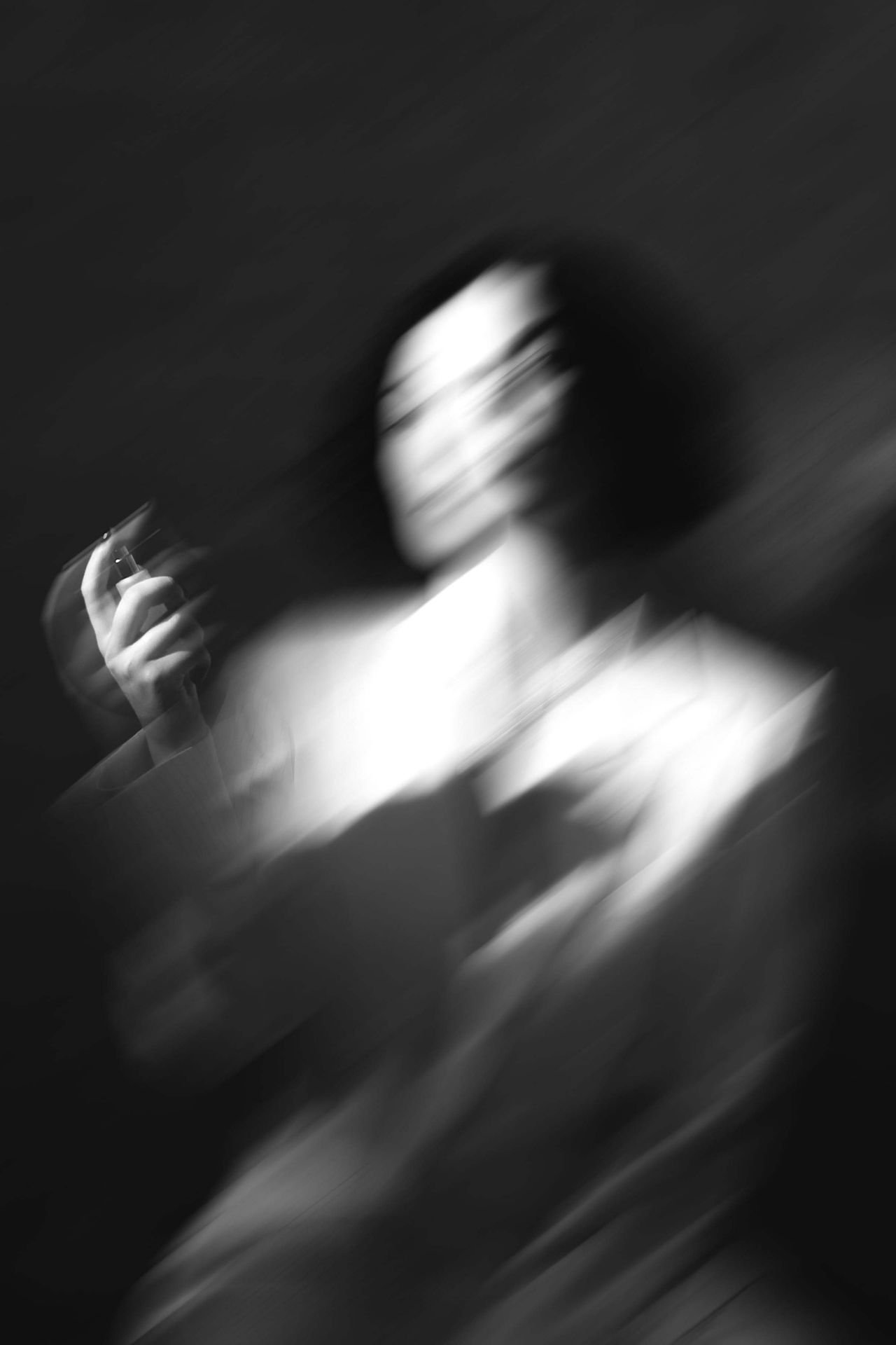 blurred image of woman spraying perfume