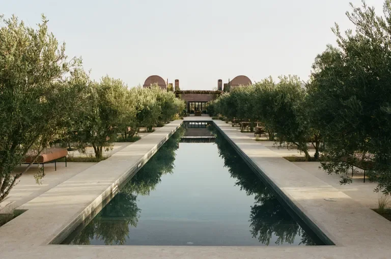 A long swimming pool leading to a hotel