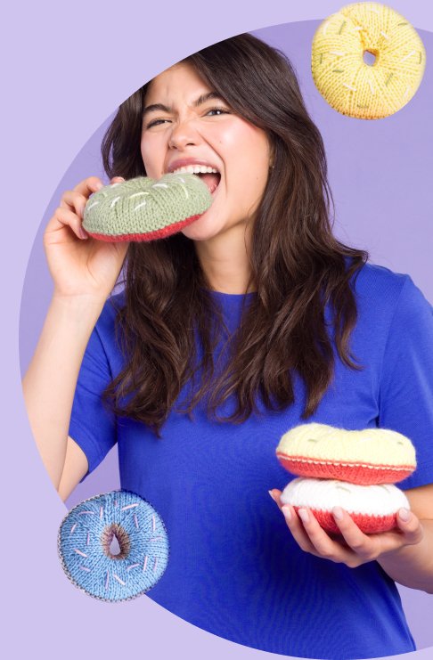 Young woman biting into a knit donut